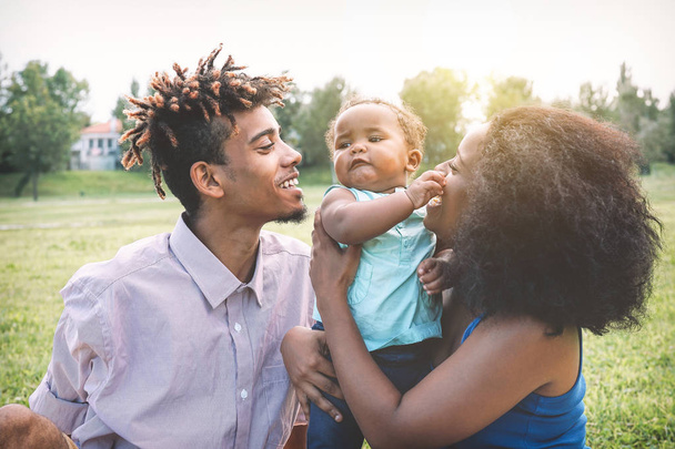 Szczęśliwa rodzina czarny, ciesząc się pojęciem przetargu moment w weekendy odkryty - matka i ojciec zabawy z córką w parku publicznym - miłość, rodzice i szczęścia - Zdjęcie, obraz