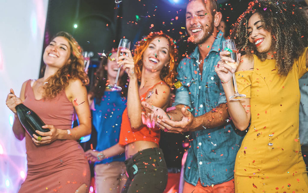 Happy friends doing party drinking champagne and dancing in the club - Millennials young people having fun celebrating in the nightclub - Nightlife, entertainment and festive holidays concept - Photo, Image