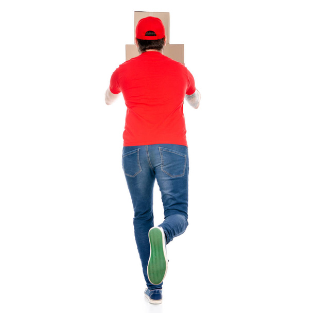 Delivery man in red uniform holding box package back view - Photo, Image