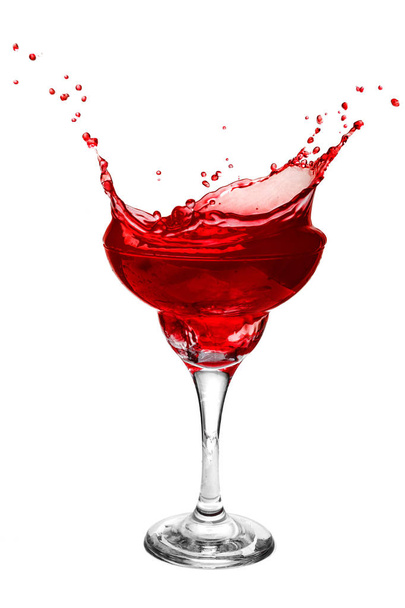 A glass with a red drink closeup on a white background. Splash drink. - Fotoğraf, Görsel