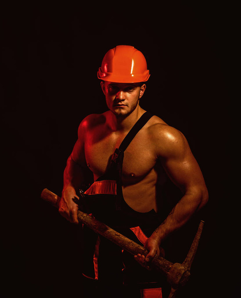 We renovating, under construction. Construction worker. Muscular man worker. Hard worker with muscular torso. Man miner with mining equipment. Mining area under construction - Foto, afbeelding