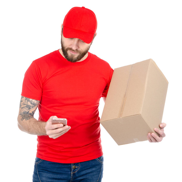 スマート フォンでボックス パッケージを保持している赤で統一の配達人 - 写真・画像
