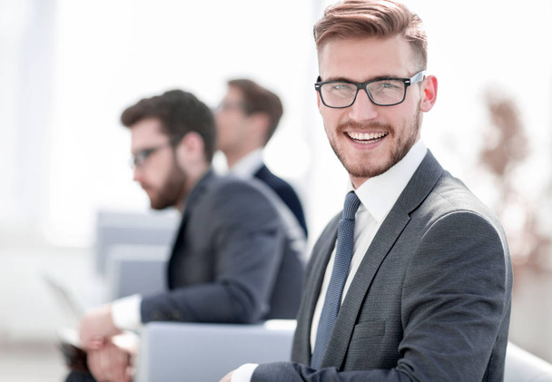 smiling businessman on blurred office background - 写真・画像