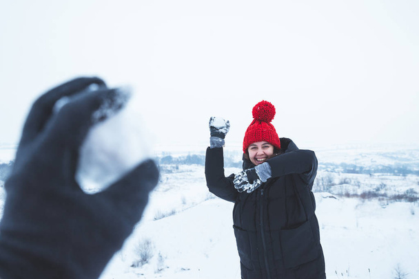casal brincando ao ar livre no tempo de inverno. mulher jogando bola de neve. homem primeira vista ponto
 - Foto, Imagem