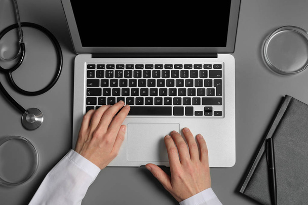 Hallgató modern laptop és orvosi cucc asztalnál, felülnézet - Fotó, kép