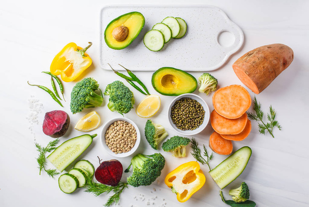 Vegan food background. Balanced food ingredients on a white background, top view. Vegetables, legumes for cooking healthy salad. - Foto, Imagem