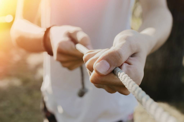 closeup of the hands pulling the rope with force - Foto, afbeelding