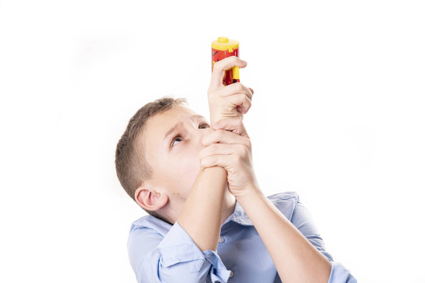 Çocuk bir konfeti tabanca beyaz bir arka plan karşı havaya ateş eder - Fotoğraf, Görsel