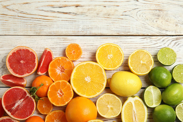 Different citrus fruits on wooden background, top view. Space for text - Φωτογραφία, εικόνα