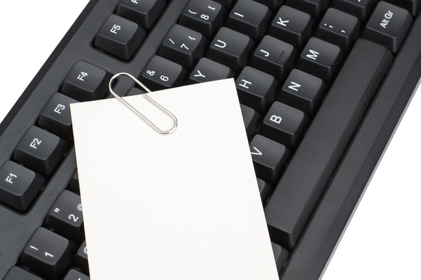 toetsenbord van de computer en een schone lei voor notities memo's. op een wit - Foto, afbeelding