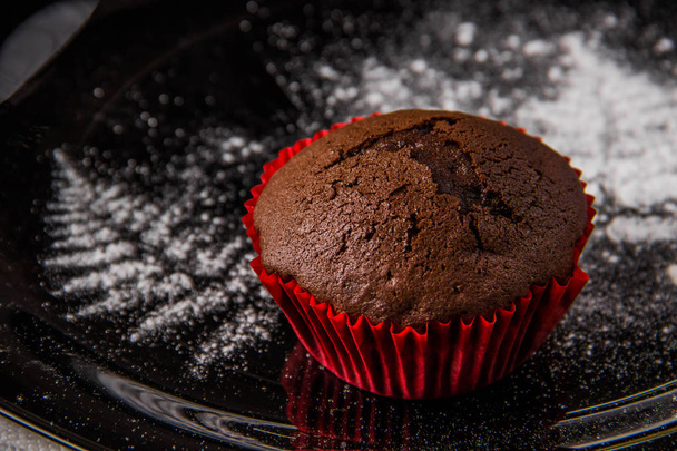 Schokoladenmuffins auf dunklem Hintergrund mit Puderzucker - Foto, Bild
