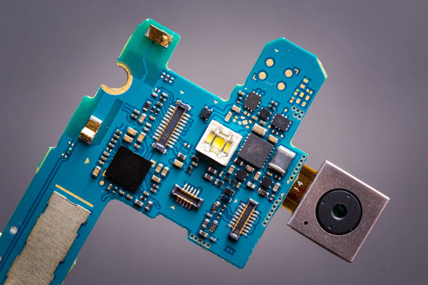 Blauwe printplaat van smartphone met de module van de camera op een lintkabel. - Foto, afbeelding