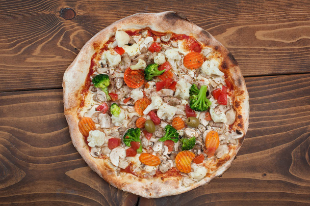 Fresh italian vegetariana pizza on wooden background, top view. Delicious italian fast food - Photo, Image