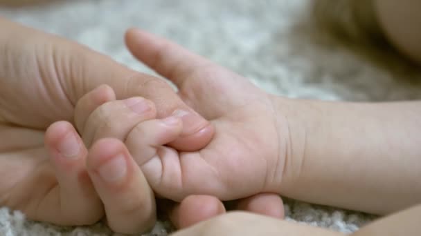 Moeder houdt kleine kinderen palm in haar hand. Close-up - Video