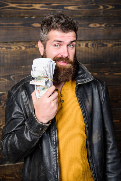 Richness and wellbeing. Man brutal bearded hipster wear leather jacket and hold cash money. Mafia business. Illegal profit and black cash. Guy mafia dealer with cash profit. Brutal man has cash money - Foto, imagen