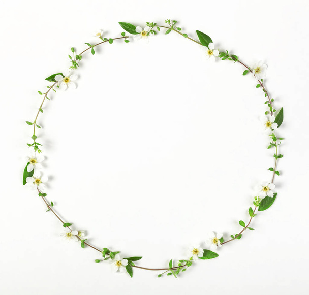 Round frame wreath made of spring wildflowers and leaves isolated on white background. Top view. Flat lay. - Photo, Image