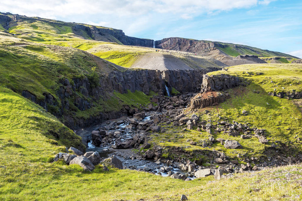 Paisaje del barranco con cursos de agua que descienden de las cascadas de Hengifoss y Litlanesfoss en el municipio Fljotsdalshreppur del este de Islandia
  - Foto, imagen