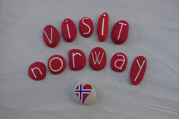 Visite Noruega con bandera nacional con piedras de mar de colores sobre arena blanca
 - Foto, imagen