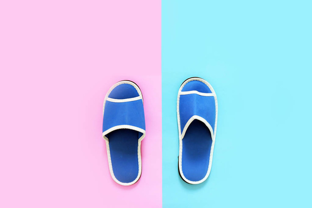 Pop-Art pár prázdných měkké modré domácí pantofle izolované, minimalistický Trend. Postel modré boty příslušenství od hotelu. Domácí obuv (sandály) na pastelové barvy azurová a růžové pozadí šablony, kopie prostor, pohled shora. - Fotografie, Obrázek