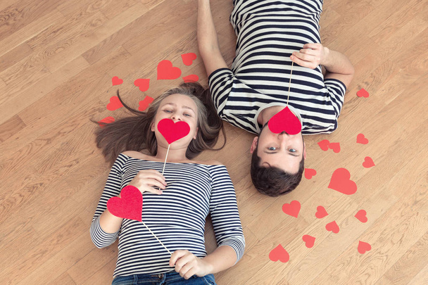 Top view young couple lying on the floor and looking to camera and smile. - Foto, Imagem