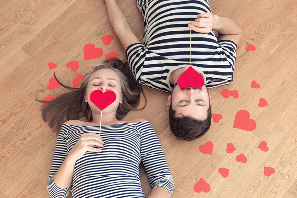 Young happy valentines couple lying on the floor with closed eyes. - Fotoğraf, Görsel