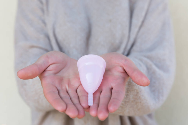 The menstrual cup is holding by woman hands. Selective focus. - Photo, image