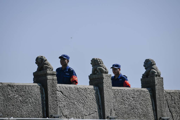 Security guards walk on the Lugou Bridge, also called the Marco Polo Bridge, during the 80th anniversary of the beginning of the War of Chinese People's Resistance Against Japanese Aggression in Beijing, China, 7 July 2017 - Valokuva, kuva