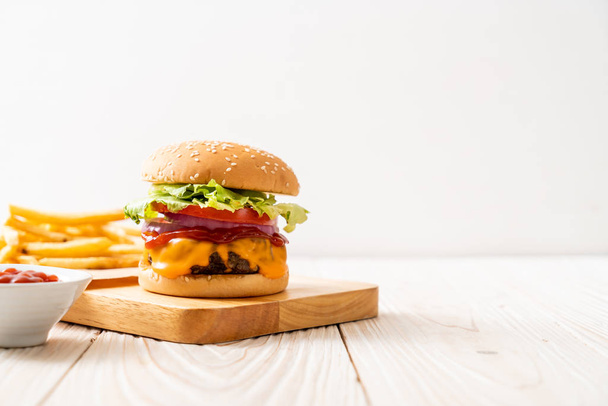 fresh tasty beef burger with cheese and ketchup on wood background - Fotó, kép