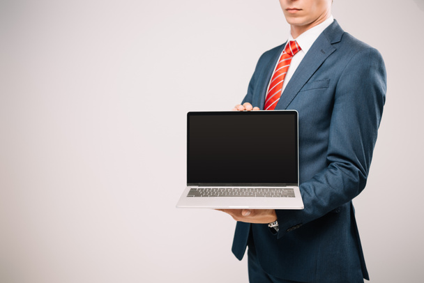 vue recadrée de l'homme d'affaires en costume montrant ordinateur portable isolé sur gris
 - Photo, image