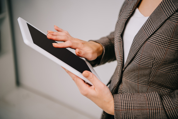vue recadrée sur femme d'affaires utilisant et touchant tablette numérique isolé sur gris
 - Photo, image
