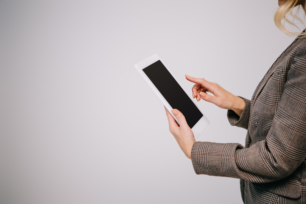 vista recortada en mujer de negocios utilizando tableta digital aislada en gris con pantalla en blanco
 - Foto, imagen