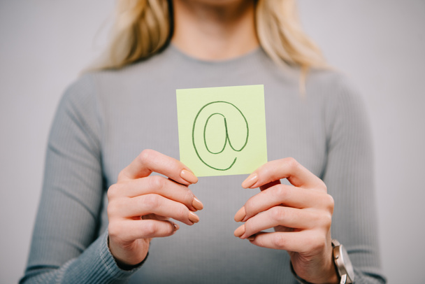 Kırpılan görünümü gri izole e-posta işareti ile kağıt not tutan kadın - Fotoğraf, Görsel