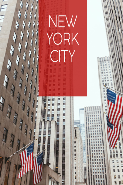 low angle view of skyscrapers and american flags on new york city street with "new york city" lettering, usa - Foto, Imagem