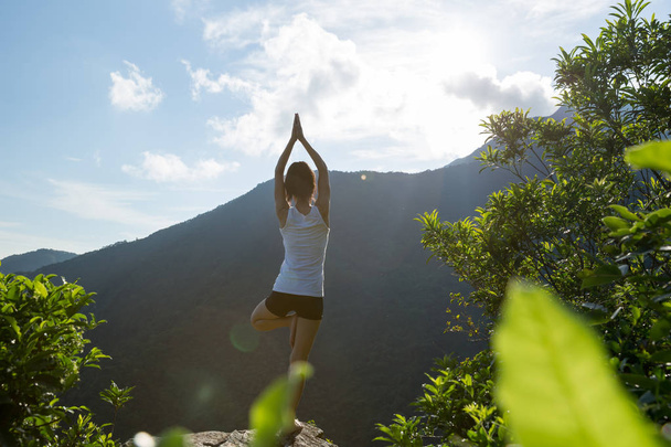 Yoga woman meditating on mountain peak cliff edge in sunrise - Zdjęcie, obraz