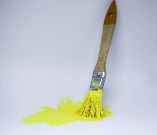 Escova com tinta amarela sobre fundo branco - Foto, Imagem