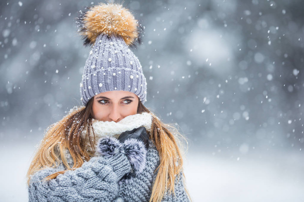 Portrait of young beautiful woman in winter clothes and strong snowing. - Foto, Imagem