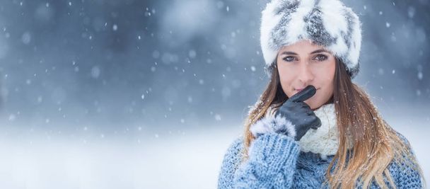 Portrait of young beautiful woman in winter clothes and strong snowing. - Foto, imagen