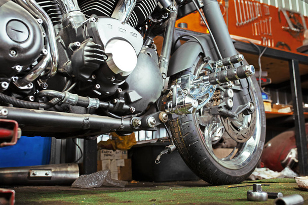 Обрізаний крупним планом знімок красивого і нестандартного мотоцикла в майстерні
 - Фото, зображення
