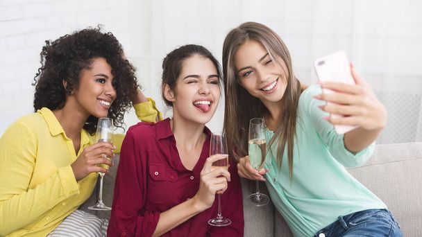Jonge vrouwen selfie te nemen en het drinken champagne - Foto, afbeelding