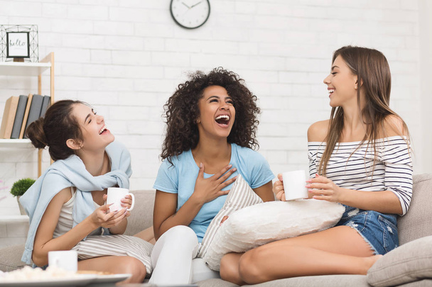 Happy female friends chatting and drinking coffee at home - Фото, изображение