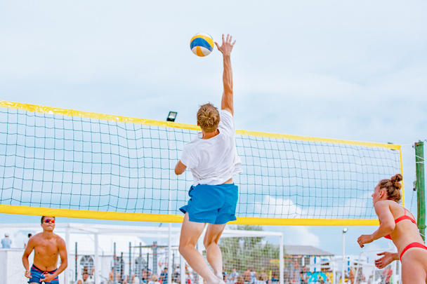 Волейбол пляжний гравець чоловічий спортсмен волейболіст готується подавати м'яч на пляжі
. - Фото, зображення