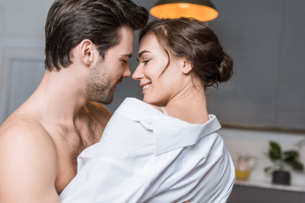 adult tender couple embracing and smiling at home - Foto, afbeelding