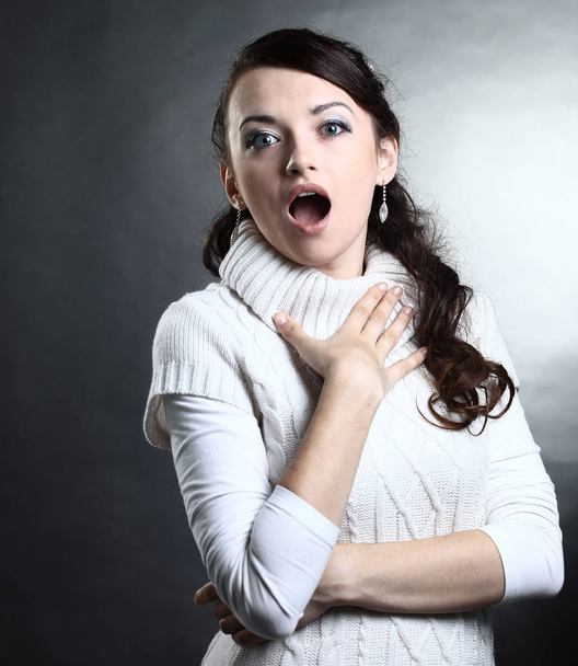 portrait of a surprised young woman in white sweater .isolated - Photo, image