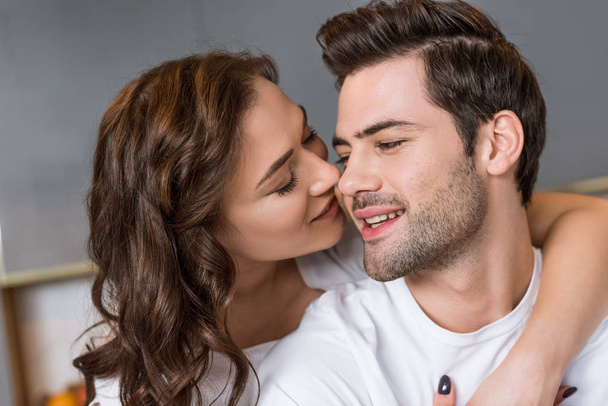 close up of attractive girlfriend kissing cheek of handsome boyfriend  - Fotoğraf, Görsel