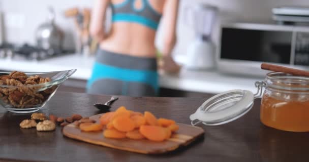Young woman is prepare and eating a healthy oatmeal after a workout. - Materiaali, video