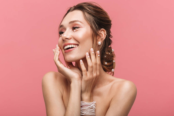 Photo of a beautiful happy cheerful young woman posing isolated over pink wall background. - 写真・画像