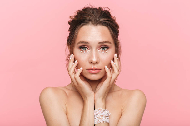 Beauty portrait of an attractive young topless woman posing isolated over pink background, wearing white pearls - Zdjęcie, obraz