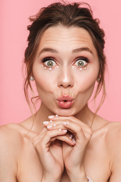 Photo of a beautiful shocked happy young woman posing isolated over pink wall background. - Foto, imagen