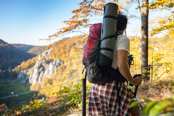 Man with big backpack trekking on mountain trail with landscape view - Foto, imagen