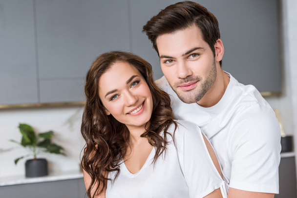 cheerful romantic couple smiling while looking at camera  - Foto, afbeelding